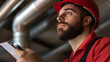 © A2Z AI  - Focused worker with a red hardhat and clipboard inspecting overhead pipes. He embodies diligence in industrial maintenance, ensuring quality work, and promoting safety.