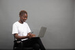 © Vic Josh - A young black female working on laptop computer isolated on grey background