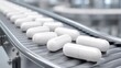 © liliyabatyrova - White capsules glide smoothly on a conveyor belt inside a clean, spacious pharmaceutical factory. The environment is bright and organized, emphasizing the efficient production process