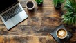 © Ummeya - Laptop coffee and plants arranged on a rustic wooden surface overhead view