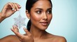 © Vasiliy - Woman with glowing skin holding a silver snowflake ornament. Winter beauty and skincare concept for the christmas holiday season