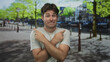 © Krakenimages.com - Man with crossed arms pointing both index fingers to opposite sides on a city street by a canal walkway; indecision.
