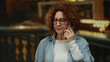 © Krakenimages.com - Woman talking on phone inside a dimly lit church setting, conveying a thoughtful expression, emphasizing a serene indoor environment with warm lighting and religious ambiance.