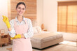 © New Africa - Chambermaid with cleaning gloves in hotel room