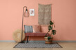 © Pixel-Shot - Floor lamp, bench and houseplant near coral wall in interior of living room