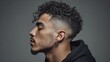 © Popu - Stylish young man with vibrant curly hair and modern fade haircut posing in studio portrait
