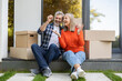 © zinkevych - Senior couple sitting at front door with keys enjoying new property