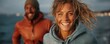 © Georgii - Smiling couple enjoying an outdoor adventure on a windy day during sunset