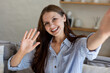 © zinkevych - Smiling female taking selfie and showing greeting gesture waving hand