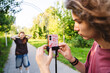 © TrueShot | Westend61 - Teen recording friend with smartphone outdoors for social media content