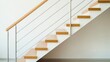 © Agus - Modern wooden stairs with light metal railing against a white wall