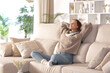 © Antonioguillem - Relaxed woman at home sitting on a comfortable couch in winter