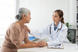 © amnaj - Doctor offering compassionate care and support to an elderly woman in a hospital or clinic setting, focusing on empathy