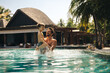 © Jacob Lund - Father and son enjoying a luxury island resort swimming pool