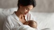 © Chandlerlikes - Loving mother feeding her baby with breast milk while resting on bed, home environment, calm and tender moment