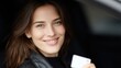 © Chandlerlikes - Smiling female showing her driver license inside her car, happy and confident as a new driver, youthful and pleased expression