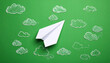 © theshooter - Avión de papel blanco sobre fondo verde con nubes blancas concepto de viaje, imaginación creatividad. para campañas de comunicación, viajes educación nuevas metas. o emprendimiento creativo