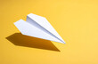 © theshooter - Avión de papel blanco sobre fondo amarillo, imagen minimalista concepto de viaje, imaginación creatividad. para campañas de comunicación, viajes educación nuevas metas. o emprendimiento creativo