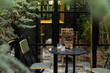 © Natasha Lee - patio table and chairs tucked away in a cozy, leafy indoor outdoor cafe with mirror doors and lots of green and tile floors in europe