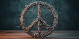 Woven barbed wire peace symbol against a dark background, conveying conflict and disruption.