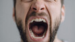 © THESUN - Close up portrait of an angry man screaming with intense emotion. face shouting in rage and frustration due to problem or mental stress
