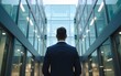 © hao - A man stands in front of a modern glass business center. Back view. High quality