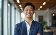 © handong - Young Asian businessman standing in an office smiling confidently. High quality
