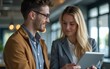 © David - He trusts her business instincts. Shot of two coworkers talking together over a digital tablet in an office. High quality