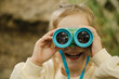 © Westend61 - Smiling child exploring outdoors with binocular in nature