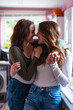 © Westend61 - Lesbian couple embracing and smiling at home in casual clothing