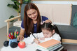 © itchaznong - Nurturing Learning Environment: Mother Assisting Daughter with Homework