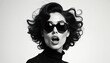 © Pete - Stylish young woman wears big chic sunglasses, black turtleneck. Glamorous voluminous curly hair. Mouth open in surprised amazed expression. Bold black, white studio portrait shows modern fashion