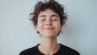 © vadosloginov - Smiling young person with curly hair enjoys a moment of happiness indoors