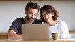 © olga_demina - Happy mature couple wearing eyeglasses using laptop together, browsing internet at home, reading good news in email or searching for real estate property online, checking mortgage, paying bills