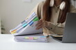 © Wasan - Office worker browsing through stack of documents at desk.