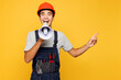 © ViDi Studio - Young employee laborer man wear helmet overall scream in megaphone announces discounts sale point aside isolated on plain yellow background. Instruments renovation apartment room. Repair home concept.