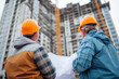 © Alena - Construction engineers discussion with architects at construction site or building site of highrise building with blueprints.