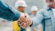 © ryker - Handshake contractor subcontractor agreement construction site meeting between two workers showing cooperation and professionalism in work environment