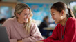 © Tessa - Young woman and student smiling while studying together in classroom