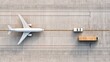 © Lady O - Aerial view of an airport terminal with an airplane and an unloading platform for cargo delivery, from a top-down perspective.