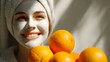 © Jojo* - Young woman with facial mask smiles brightly next to pile of fresh citrus fruit