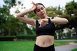 © Thitiporn - Young woman checking time on smartwatch while exercising outdoors. Concept of fitness tracking, workout routine, health monitoring, and active lifestyle with wearable technology.