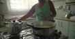 © Marco - African American Elderly woman stirring rice in a pot, showcasing skill, tradition, and the love of preparing a homemade meal in an intimate kitchen atmosphere