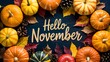 © Pixels Stock - Hello november text surrounded by a festive autumn harvest of colorful pumpkins gourds and fall leaves on a dark wooden background