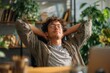 © DIMENSIONS - Young man relaxing in home office with hands behind head enjoying break stress relief indoor plants cozy environment casual attire self-care mental health balance peaceful atmosphere