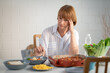 © sutthinon602 - Elderly retired grandmother stay at home with painful face sitting alone on eating table in house. Depressed mature senior old woman upset feeling unhappy. Lonely and missing his family at home