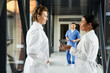 © LIGHTFIELD STUDIOS - Diverse medical professionals collaborate in a modern hospital corridor
