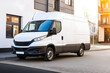 © Adi - White Delivery Van Parking Near Modern Building on Sunny Street. Mock up promotion information for marketing announcements and details, blank white space.