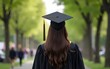 © Victoria - graduate in cap and gown with trees on the side. High quality