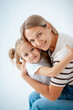 © Any Grant - mother and child with daughter, maternal love and care, mother and child hug and kiss on a white isolated background